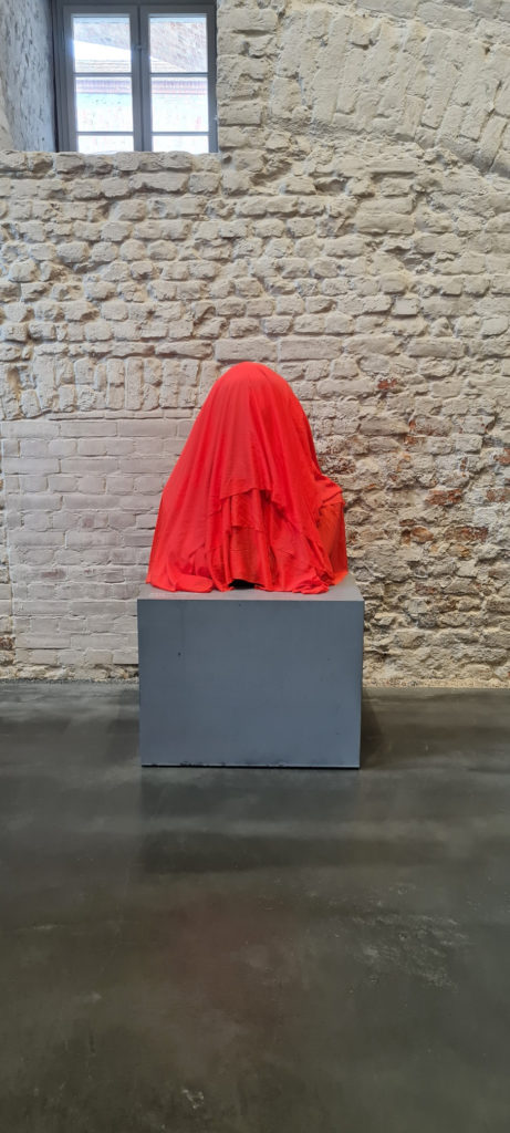 Photo of the exhibition space at Spandau Citadel, showing the bust of Karl Marx covered with a red clothFoto des Ausstellungsraums in der Zitadelle Spandau mit Blick auf die mit einem roten Tuch verhüllte Büste von Karl Marx
